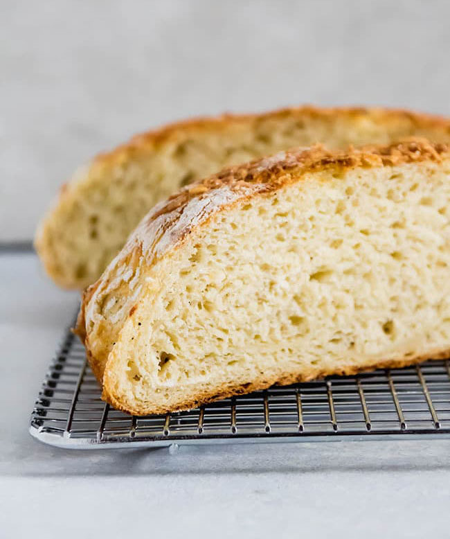 loaf of bread cut in half on a wire cooling rack