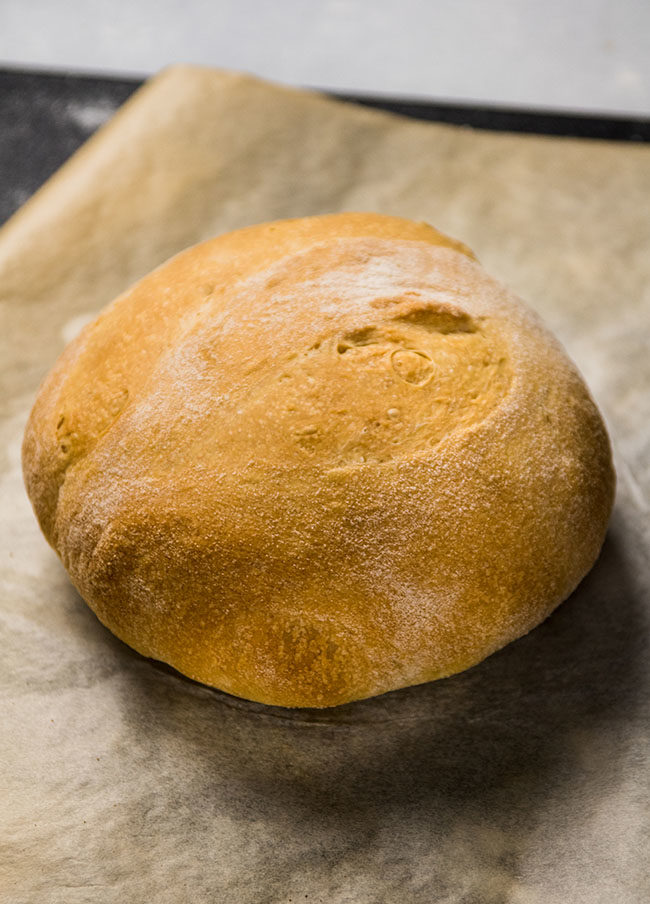 loaf of crusty bread on a sheet of parchment paper