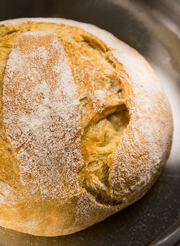 loaf of crusty french bread in a metal pot