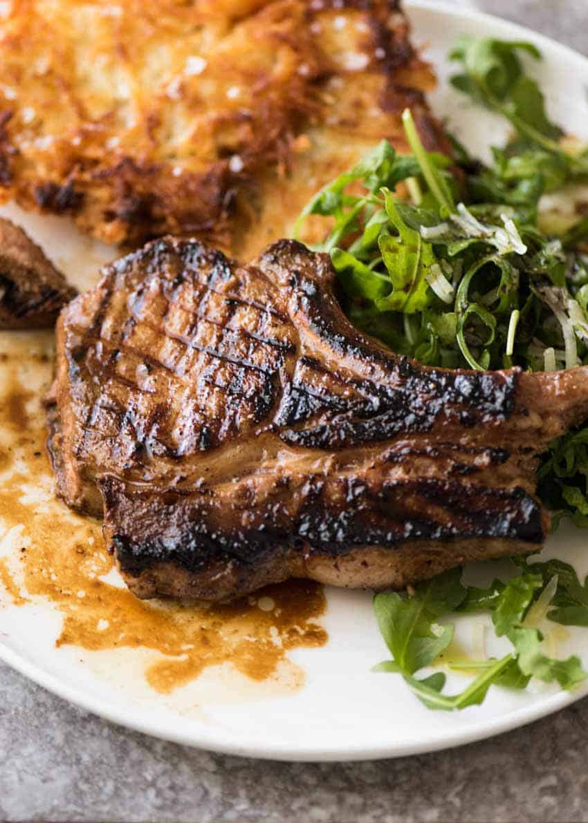 Overhead photo of Grilled chops on a plate with potato rosti and salad, made using amade using a great Pork Chop Marinade